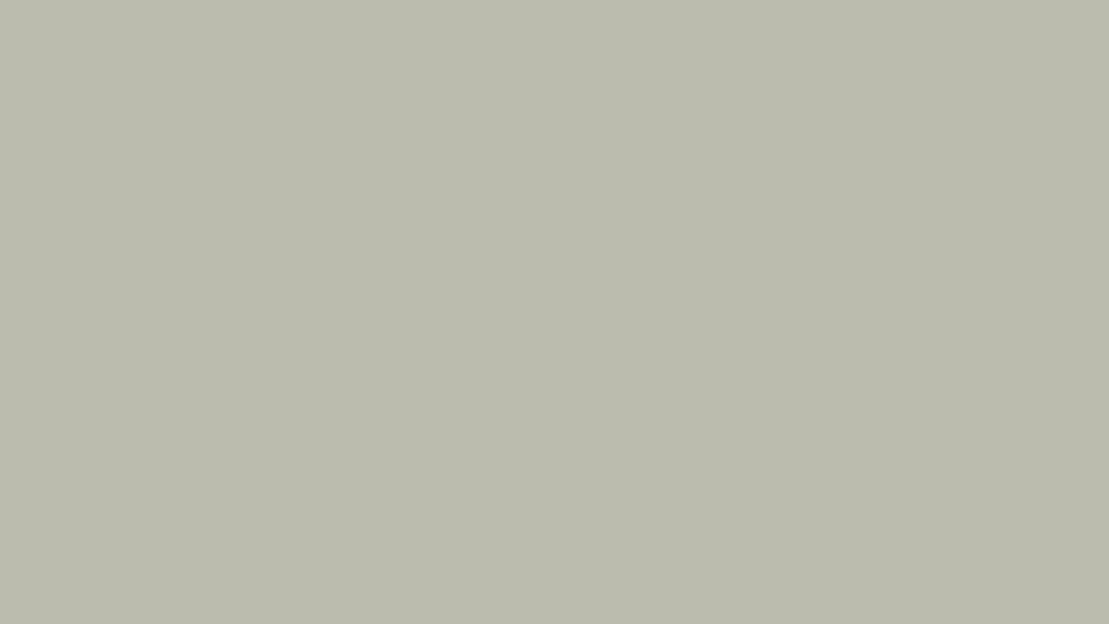 A serene beach scene with gentle waves lapping at the shore. The sky is overcast, creating a calm and peaceful atmosphere, with muted, earthy tones.