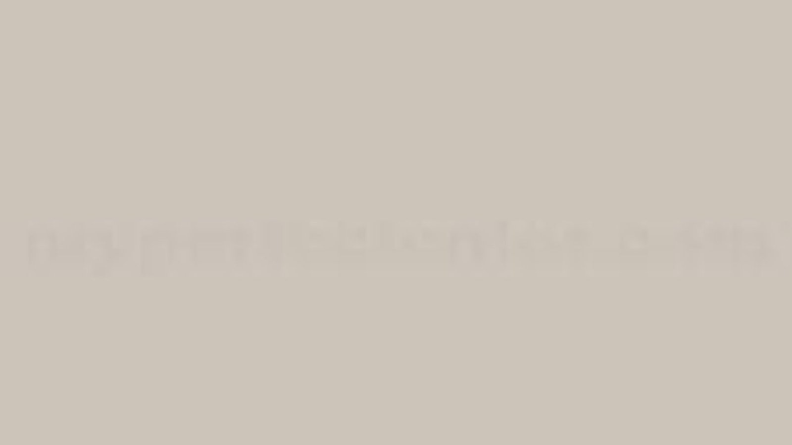 A blurry gray and beige gradient, creating an abstract, soothing background with no distinct shapes or elements, evoking a calm, neutral tone.